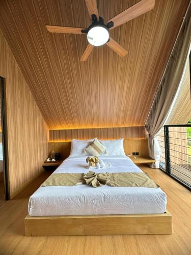 een slaapkamer met een bed met een plafondventilator bij Sai Wana Cabin Bedugul in Bedugul
