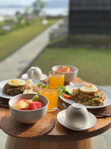 een houten tafel met borden eten en drinken bij Sai Wana Cabin Bedugul in Bedugul