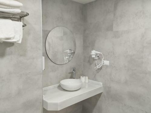 a bathroom with a white sink and a mirror at Los Helechos in Sanlúcar de Barrameda