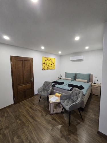 a bedroom with a bed and a couch and a table at CitrusLiget Vendégház in Palkonya
