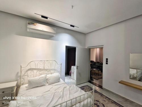 a bedroom with a white bed in a room at Al manama villa 2 in á¸¨aÅŸat al BidÄ«yah