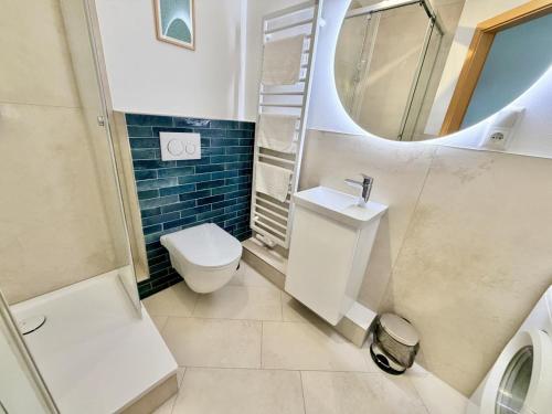 a bathroom with a toilet and a sink and a mirror at Kajuete, direkt am Kurpark in Warnemünde