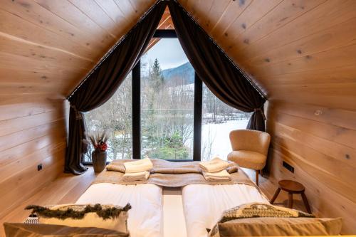 a bedroom with a large window in a log cabin at Zacisze Gór by Apart Concept Podhale in Zakopane