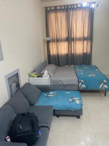 un soggiorno con un divano e un letto di DELUXE Studio Apartment a Sharjah
