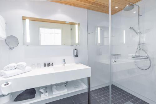 a white bathroom with a sink and a shower at Hotel Levi Panorama in Levi