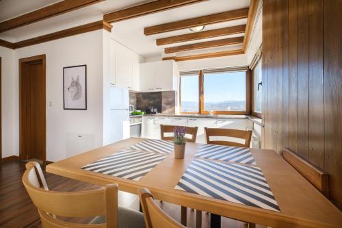 een keuken en eetkamer met een houten tafel en stoelen bij Hotel Razlog in Razlog