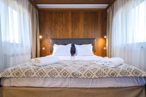 een slaapkamer met een groot bed met witte kussens bij Hotel Razlog in Razlog