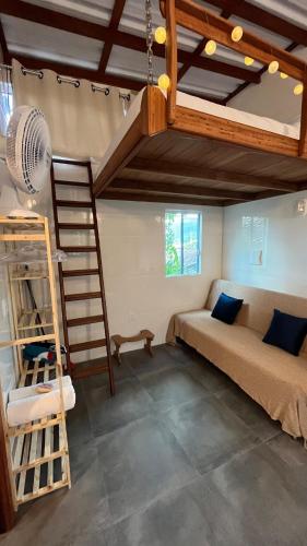 a room with a bunk bed and a ladder at Tiny House Armação no Morro in Florianópolis