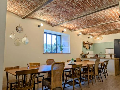 een eetkamer met een grote houten tafel en stoelen bij L'Ancienne Boulangerie in Chavagnes