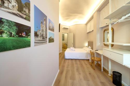 a bedroom with a white bed and paintings on the wall at Residence Concordia in Gorizia