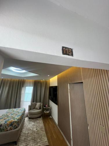 ein Hotelzimmer mit einem Bett, einer Couch und einem Fernseher in der Unterkunft 113 k-chimi in Pointe-Noire