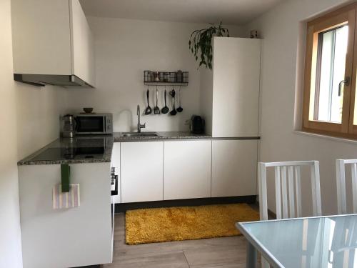 een keuken met witte kasten en een aanrechtblad bij Apartments "Am Ardetzenberg" in Feldkirch