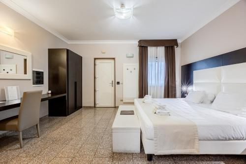 a hotel room with a large bed and a desk at EH Suites Rome Airport Euro House Hotels in Fiumicino