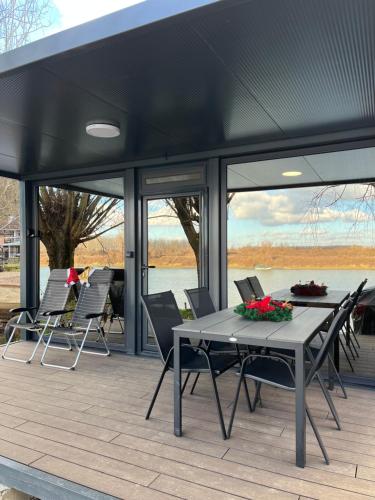 eine Terrasse mit Tisch und Stühlen auf einem Deck in der Unterkunft Altair House 