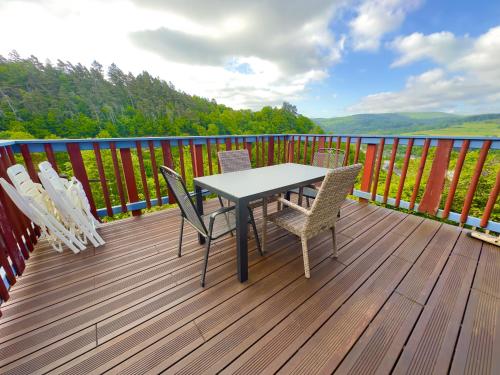 einen Tisch und Stühle auf einer Terrasse mit Aussicht in der Unterkunft Wie im Himmel in Hatzfeld