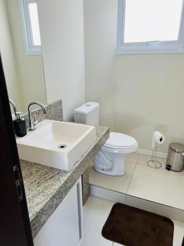 a white bathroom with a sink and a toilet at Casa condomínio lagoa cortada in Balneário Gaivotas