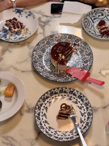 a table topped with plates of cake and desserts at WSTAR Hostel in Bangkok