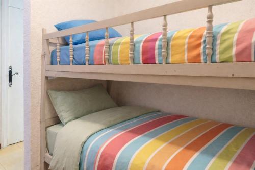 a bunk bed with colorful pillows on the bottom bunk at Les Orres Plein Sud - Studio avec balcon in Les Orres