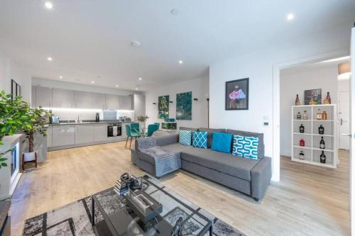 a living room with a couch and a kitchen at Stylish 1-Bed Apt in Harrow with Balcony near Heathrow and Wembley in Harrow