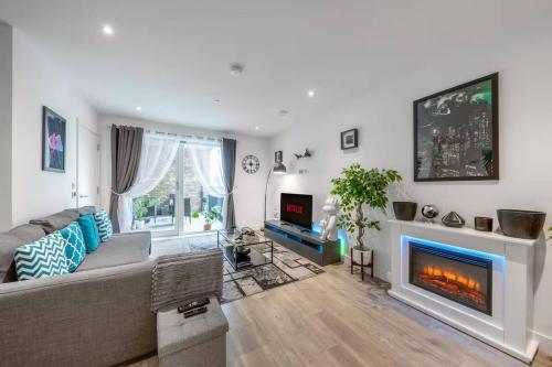 a living room with a couch and a fireplace at Stylish 1-Bed Apt in Harrow with Balcony near Heathrow and Wembley in Harrow