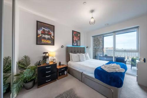 a bedroom with a bed and a large window at Stylish 1-Bed Apt in Harrow with Balcony near Heathrow and Wembley in Harrow