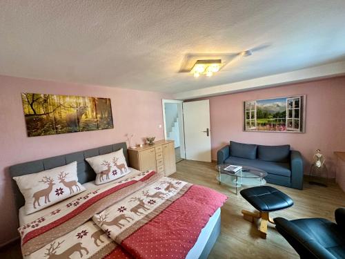 een slaapkamer met een bed en een bank bij Schwarzwald Residenz in Bad Dürrheim