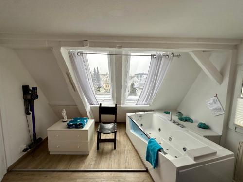 een badkamer met een groot wit bad en een raam bij Schwarzwald Residenz in Bad Dürrheim