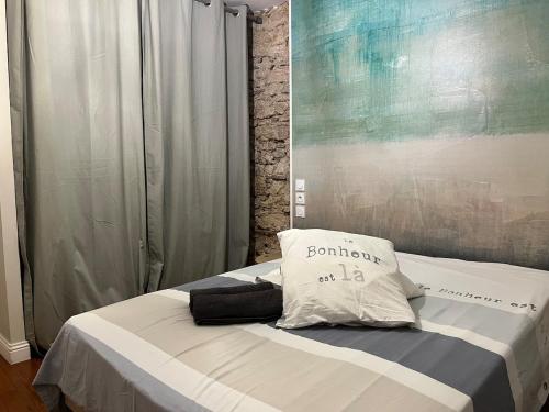 a bed with a pillow on it in a room at Le Cocon Authentique in Mont-de-Marsan