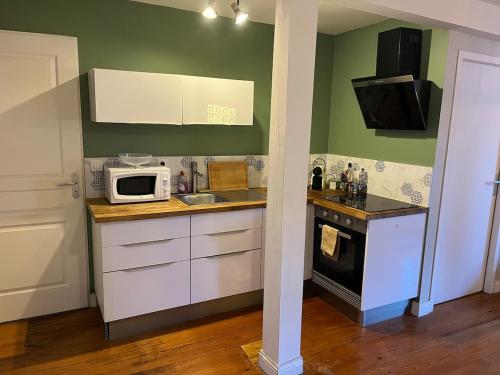 a small kitchen with a microwave and a sink at Le Cocon Authentique in Mont-de-Marsan