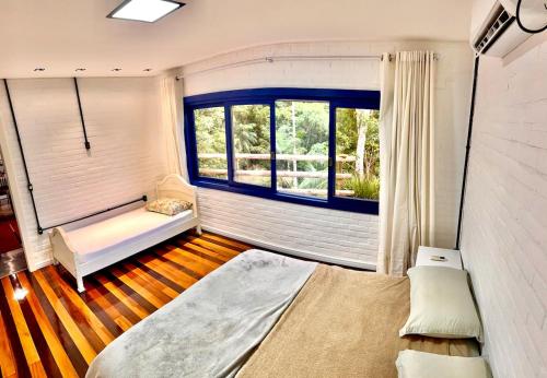 een kamer met een bed, een raam en een bank bij Sitio Dona Bela - Rio da Prata in Joinville