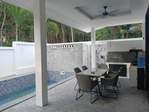 une cuisine et une salle à manger avec une table et des chaises dans l'établissement NEW! Naa rak pool villa, à Krabi