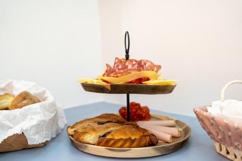 een tafel met een dienblad met brood en kaas bij Elsa d'Ortigia - I TRE ARCHI in Siracusa