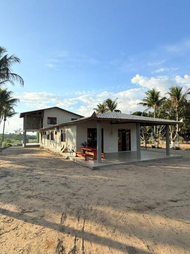 un piccolo edificio bianco con palme sullo sfondo di Obelisco hotel fazenda a Ubajara
