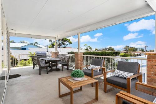 een terras met een tafel en stoelen op een balkon bij Neptune's at Manyana in Manyana
