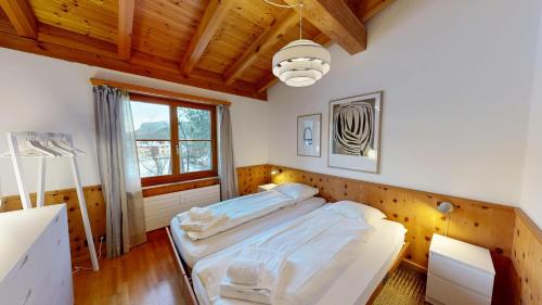 una camera da letto con un letto grande e una finestra di Apartment Pradatsch a Celerina