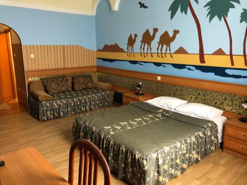 a bedroom with a bed and a couch and a painting at Volter Hotel in Lviv