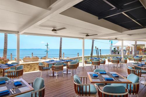 ein Restaurant am Strand mit Tischen und Stühlen in der Unterkunft Radisson Blu Resort Fiji in Denarau