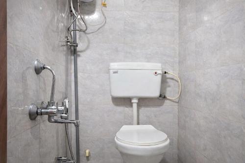 a bathroom with a white toilet in a stall at Relax Hotel Kurla in Mumbai