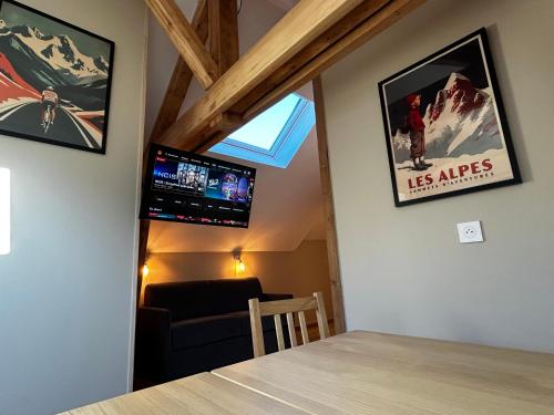 un salon avec une table, une fenêtre et une télévision dans l'établissement L'Augustine - Le Cuchet, à Saint Avre la Chambre