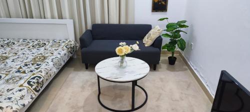 een woonkamer met een bank en een tafel met bloemen erop bij Ramco Real Estate LLC in Abu Dhabi