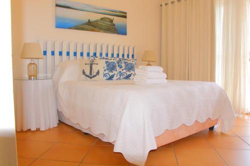 a white bed with towels on it in a room at Keke Place in Vila Praia Do Bilene