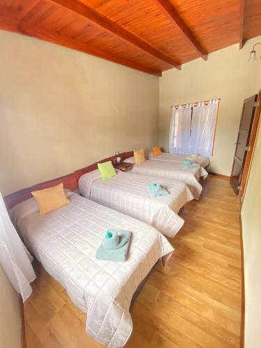 a room with three beds with towels on them at Apart Hotel Rústicos Valentina in Dolores