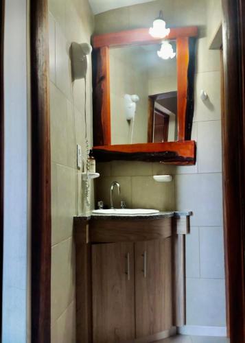 a bathroom with a sink and a mirror at Apart Hotel Rústicos Valentina in Dolores