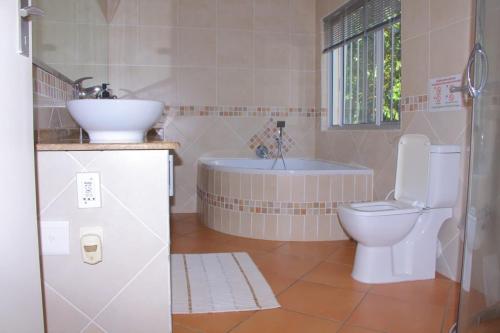 a bathroom with a sink and a toilet and a tub at Keke Place in Vila Praia Do Bilene