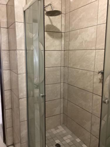 a shower with a glass door in a bathroom at Unit 5 Manzini Chalet in St Lucia