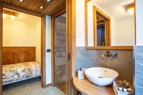 une salle de bain avec un lavabo et un lit dans l'établissement Maison Meynet Mountain Charm, à Breuil-Cervinia