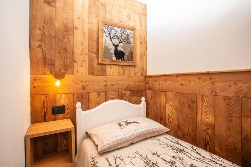 - une chambre avec des boiseries et un lit dans une pièce dans l'établissement Maison Meynet Mountain Charm, à Breuil-Cervinia