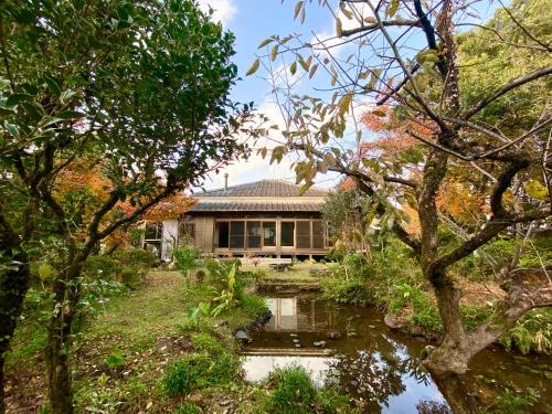 a house with a pond in front of it at 武家屋敷 無為自然ーSamurai House in Yunoo