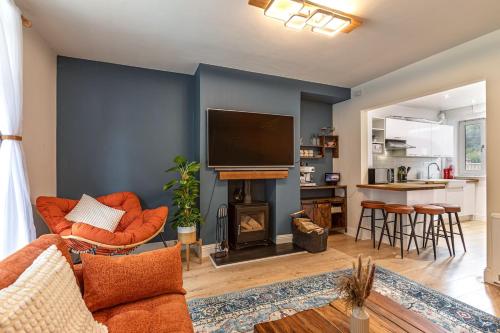 a living room with a fireplace and a tv at Yarrow cottage in Broadmeadows