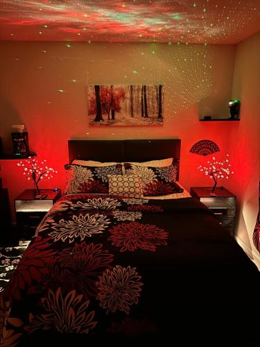 una camera da letto con un grande letto con illuminazione rossa di Japanese Theme Private Suite a Suffolk